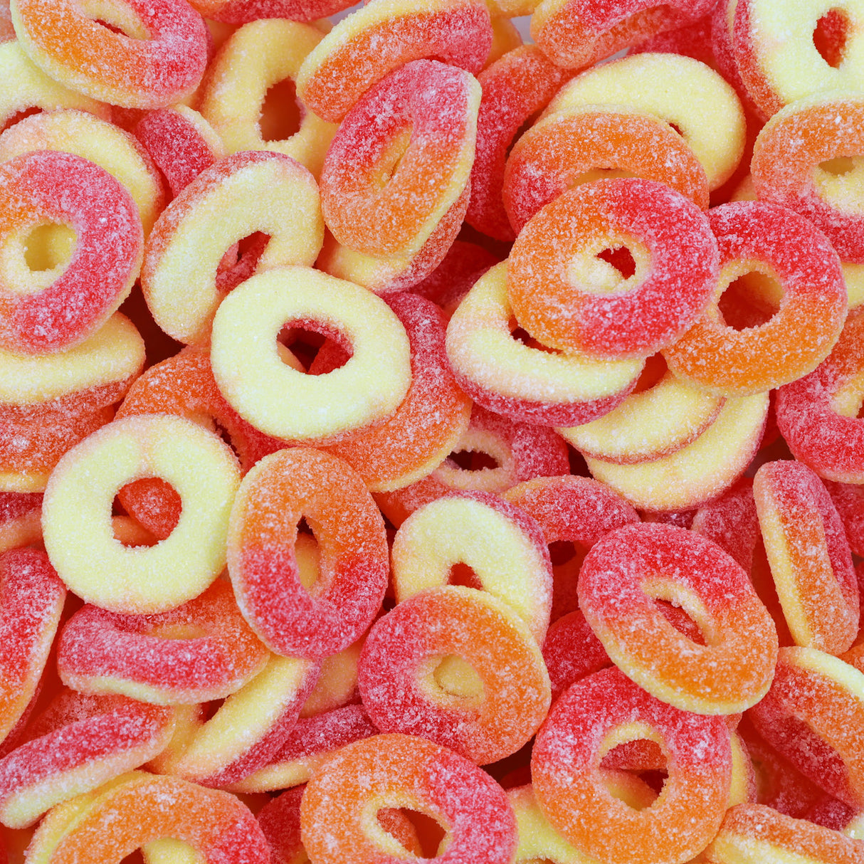 Close-up of colorful gummy rings in red, orange, and yellow.