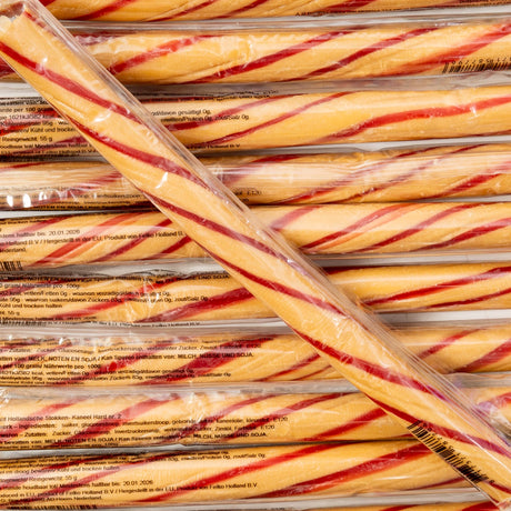 Stack of red and yellow striped candy canes in clear packaging.