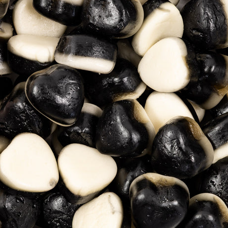 Close-up of black and white heart-shaped licorice gummies.