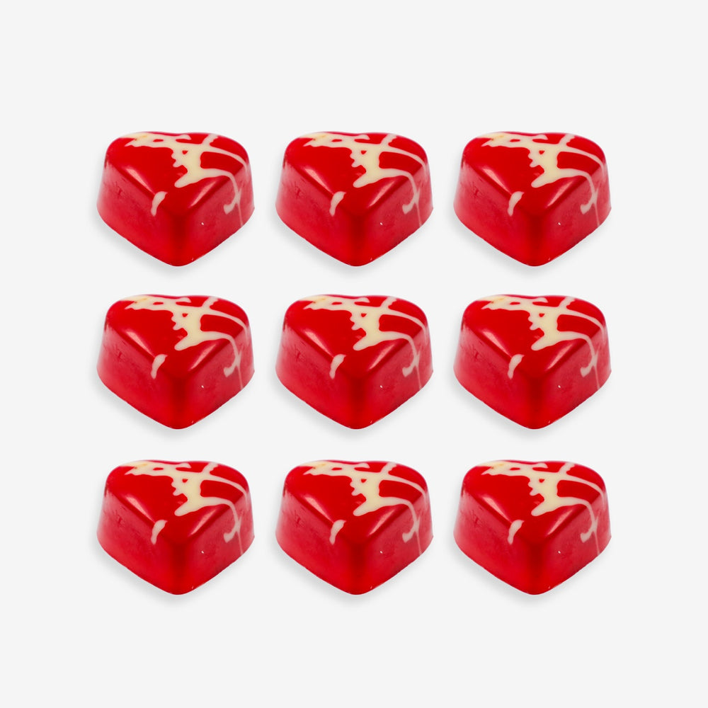 Red heart-shaped candies with white swirl patterns on a white background