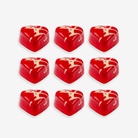 Red heart-shaped candies with white swirl patterns on a white background