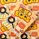 Cartoon packaging design of 'Sizzling Fried Eggs' with bears and frying pans on a bright background.